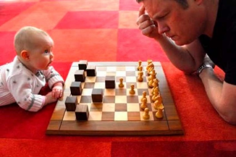 малыш учится играть в шашки